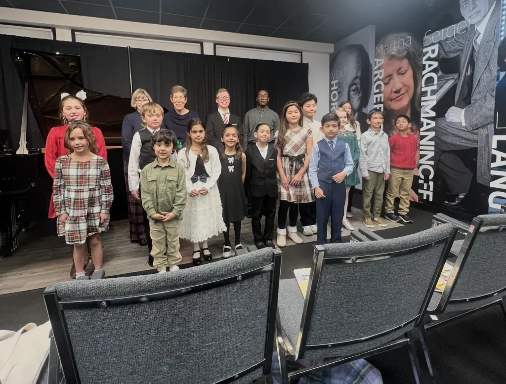 Young piano students posing after a recital performance