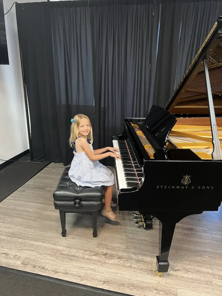 Young girl playing a Steinway & Sons grand piano